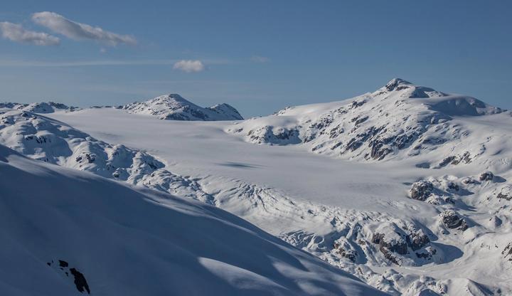 Sweeping glacier and snowy peaks under a blue sky