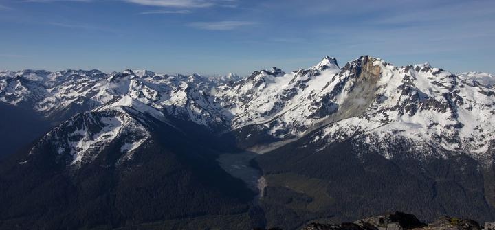 Snow-capped mountain range above a forested valley