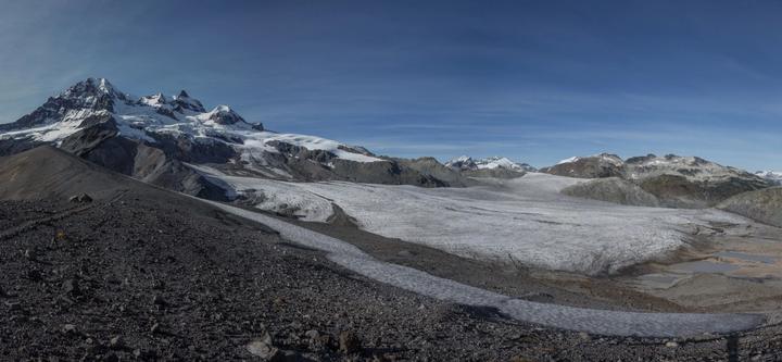 Glacier flowing beneath a rocky peak
